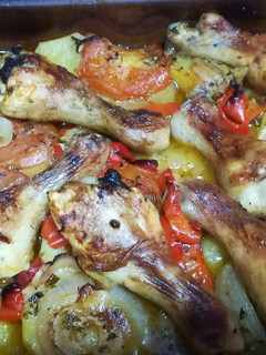 Una foto de Muslitos de pollo al horno con patatas y verduras