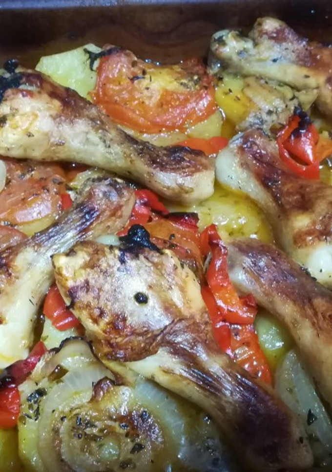 Una foto de Muslitos de pollo al horno con patatas y verduras