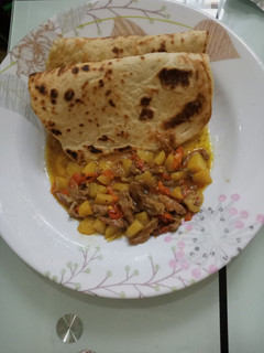A picture of Arabian Khubz with beef and potato soup.