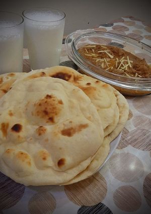A picture of Chicken Qorma with homemade naans and lassi.