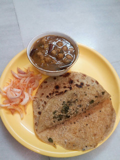 A picture of Pindi chola and bread crumbs paratha.