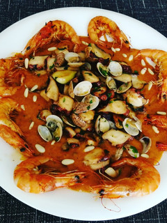 Una foto de Pulpo, chirlas y gambas sobre puré de tomate al orégano