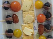 Una foto de pinchos queso tomate