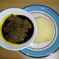 A picture of Black soup with garri.