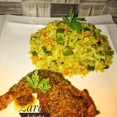 A picture of Vegetable couscous with tandoori chicken.