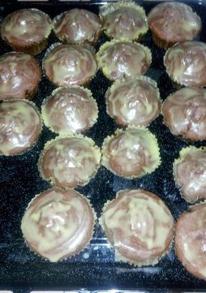 A picture of Red and green velvet cupcakes with fudge icing.