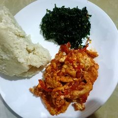 A picture of Ugali,fried sukuma (kales) and eggs.