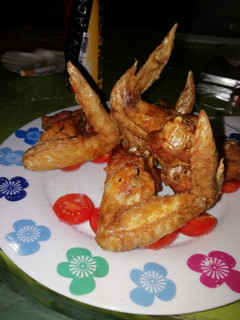 Una foto de Alitas de pollo bañadas en salsa barbacoa, miel y tomate cherry