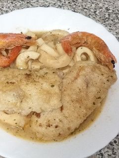 Una foto de Calamares encebollados con merluza y gambas