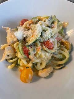 Una foto de Espaguetis de calabacín con pollo, albahaca y salsa de queso feta con tomates cherry