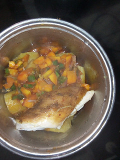 A picture of Boiled Plantain garnished with veggie sauce and chicken.