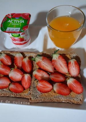 Une photo de Tartine beurre de cacahuètes et fraises accompagnées de jus d'orange maison 🍞🥜🍓🍊