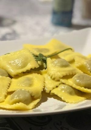 Une photo de Ravioli à la curcuma farcis au jambon, chèvre et pistaches