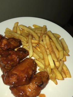 Una foto de Alitas en salsa BBQ con papas fritas