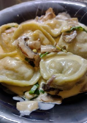 Una foto de Capeletis de albahaca rellenos de pollo con salsa de champiñones