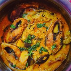 A picture of Hilsa fish cooked with aubergine in a mustard gravy.