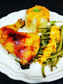 Una foto de Muslos de pollo en adobo rojo al horno y guarnición