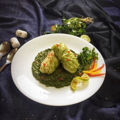 A picture of Nutty lemony cabbage roll in green sauce.