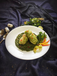 A picture of Nutty lemony cabbage roll in green sauce.