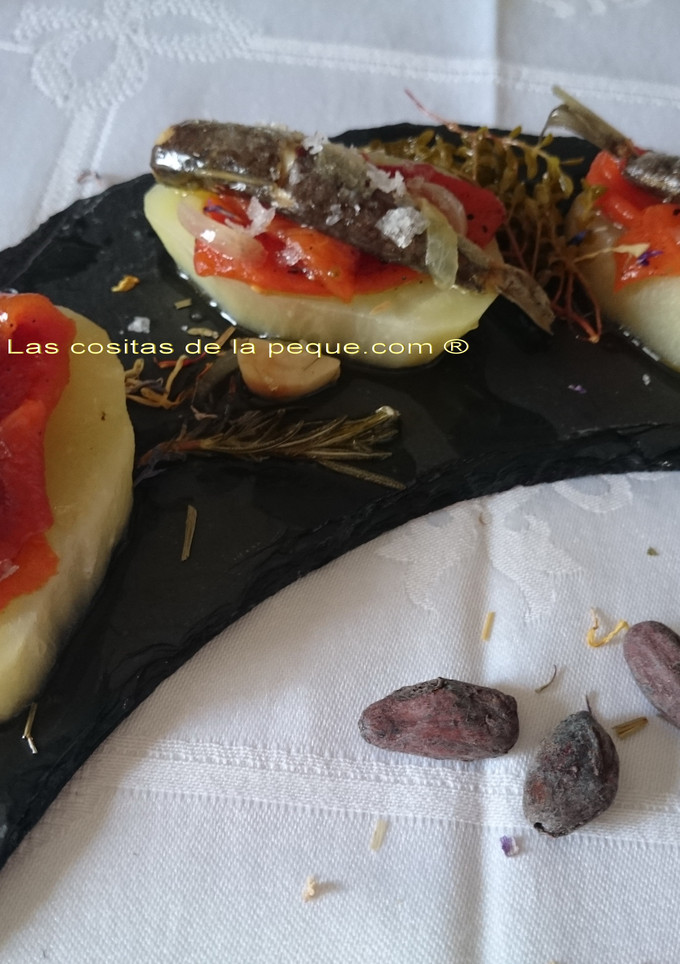 Una foto de Tapas de patata con pimientos asados, sardinas en conserva y escabeche blanco