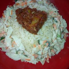 A picture of White rice and salad and Stew chicken.