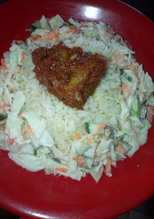 A picture of White rice and salad and Stew chicken.