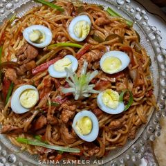 A picture of Chicken chowmein topped with quail eggs.