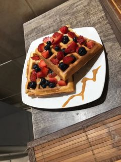 Una foto de Wafles con manjar y frutos rojos