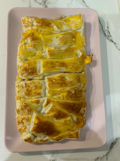 Una foto de Trenza de hojaldre rellena bacon, cebolla caramelizada y queso de cabra