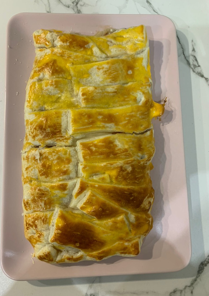 Una foto de Trenza de hojaldre rellena bacon, cebolla caramelizada y queso de cabra