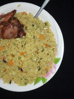 A picture of Fried rice with fried chicken.