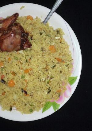 A picture of Fried rice with fried chicken.