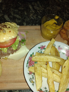 Una foto de Combo completo. Pan de hamburguesa, hamburguesa, aros fritos