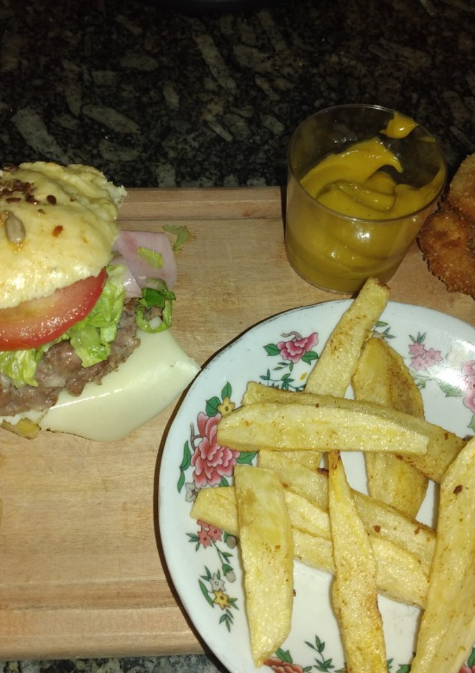 Una foto de Combo completo. Pan de hamburguesa, hamburguesa, aros fritos