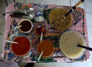 Una foto de Pozole de maíz azul y otro rojo, con veintisiete salsas para colorea, sazonar y aromatizar al gusto, tipo bufet para fiesta de 50 personas