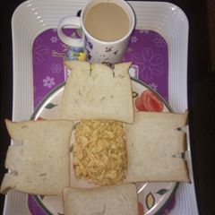 Scrambled eggs and sliced bread with cowbell coffee drink A picture of Scrambled eggs and sliced bread with cowbell coffee drink.