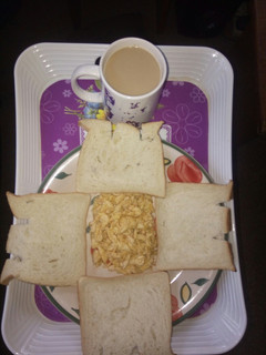 A picture of Scrambled eggs and sliced bread with cowbell coffee drink.