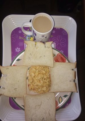 A picture of Scrambled eggs and sliced bread with cowbell coffee drink.
