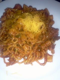 A picture of sausage with bolonaise sauce and pasta.