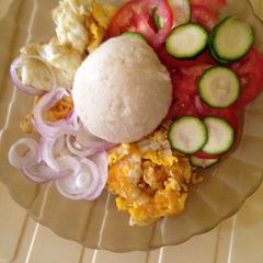 A picture of Ugali served with omlete and kachumbari.
