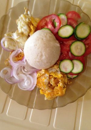 A picture of Ugali served with omlete and kachumbari.