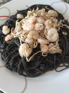 Una foto de Espaguetis negros con gulas y gambas