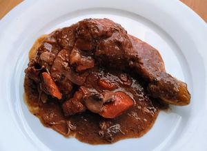 Una foto de Pollo al vino tinto "coq au vin"