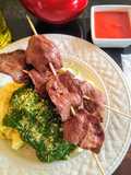 Tallarines en salsa verde con brochetas de anticucho