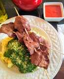 Tallarines en salsa verde con brochetas de anticucho