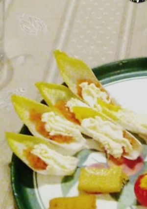 Une photo de Saumon gravlax sur feuille d'endive et chantilly citronnée