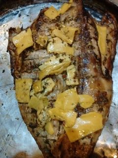 Una foto de Asado a la parrilla de anchoa de banco al chimi con ocas asadas (papines andinos)