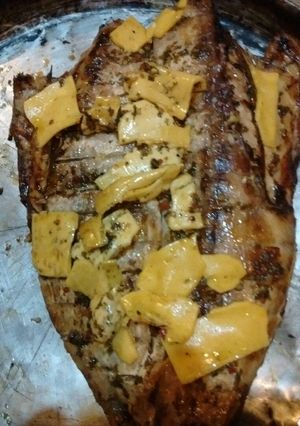 Una foto de Asado a la parrilla de anchoa de banco al chimi con ocas asadas (papines andinos)