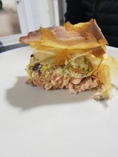 Una foto de Salmón envuelto en masa filo con relleno de pistachos en salsa
