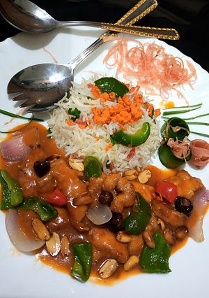 A picture of Kungpao chicken with fried rice.